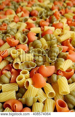Vertical Image Of Heap Of Three-color Uncooked Vegeroni Pasta With Selective Focus