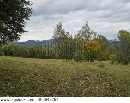 Meadow With Autumn Colorful Forest, Trees And Hills, Moody Sky. Landscape In Luzicke Hory Lusatian M