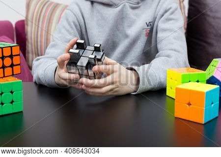 Dnipro, Ukraine - May 11, 2020 - Boy Solving Mirror Cube. Child Hands With Cube Puzzle. Colourful Cu
