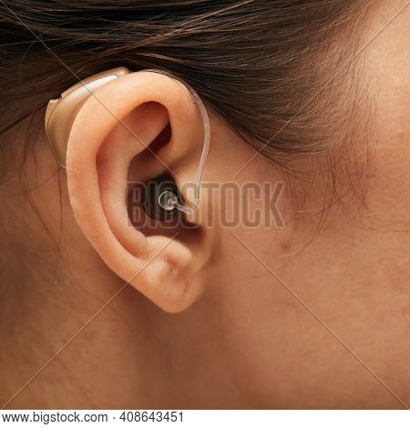 Hearing Aid Behind The Ear Woman, Close-up, Side View. Deafness Treatment, Hearing Solution