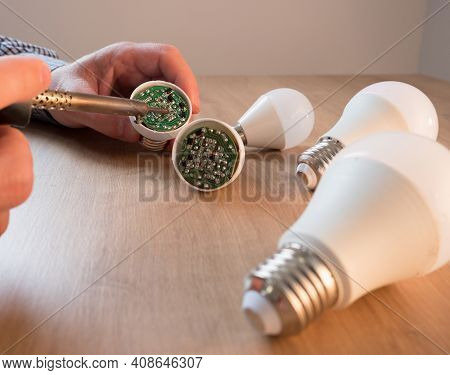 Man Repairing A Led Lamp With A Soldering Iron