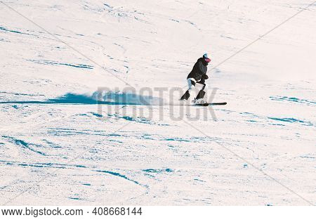 Alpine Skier Riding Down A Steep Slope On A Clear Sunny Day.