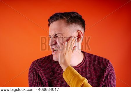 Man Getting Slapped On Orange Background. Unhappy Scared Man Getting Slapped Standing On Orange Back