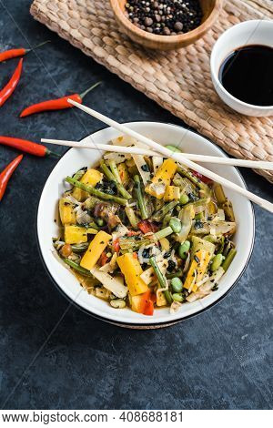 Fresh Asian Vegetables Mix, Thai Wok In A White Plate On The Black Background. Healthy Food