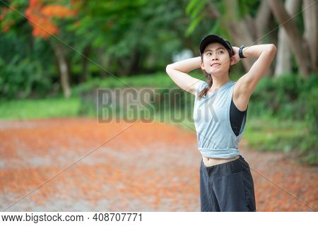 Portrait Of Runner Woman Doing Stretching And Warming Up Her Body Before Running In The Park. The Be