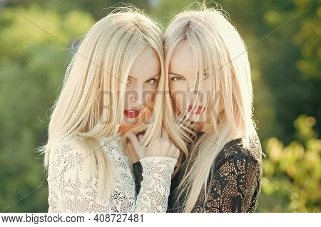 Sisters Blonde Twins Posing On Natural Landscape. Beauty And Fashion. Two Women Face