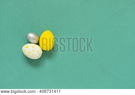 Three Colored Painted Eggs On Green Background Easter Card With Empty Space For Text. Happy Easter