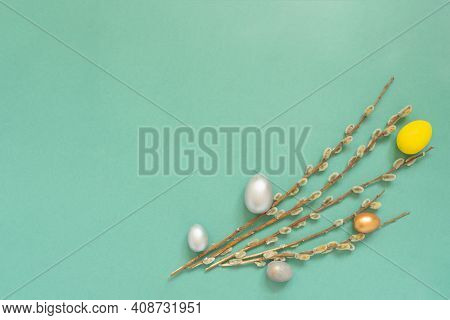 Colored Easter Eggs With Willow Branches On Color Green Background. Easter Card With Empty Space For