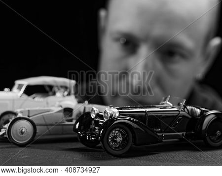 Portrait Of A Collector Of Retro Car Models On A Black Background
