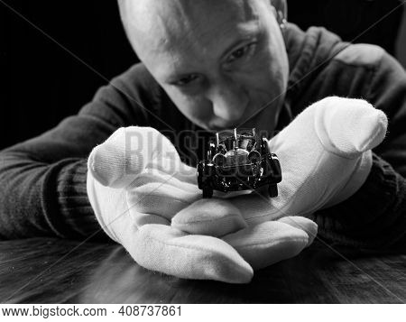 Portrait Of A Collector Of Retro Car Models On A Black Background