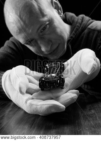 Portrait Of A Collector Of Retro Car Models On A Black Background