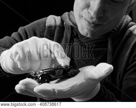 Portrait Of A Collector Of Retro Car Models On A Black Background