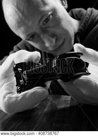Portrait Of A Collector Of Retro Car Models On A Black Background