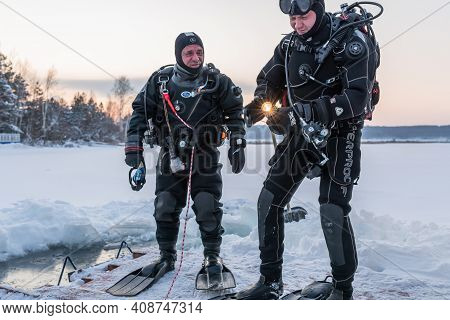 Russia, River Volga Kama - Jan 17th 2020. Diver Checks The Flashlight Torch Before Scuba Ice Diving.