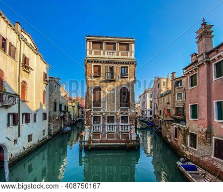 Beautiful and colorful venitian front house surrounded by water