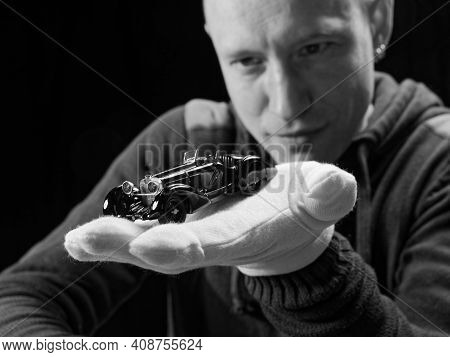 Gomel, Belarus - February 16, 2021: Portrait Of A Collector Of Retro Car Models On A Black Backgroun