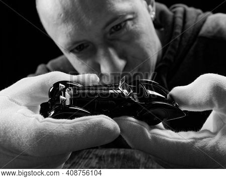 Gomel, Belarus - February 16, 2021: Portrait Of A Collector Of Retro Car Models On A Black Backgroun