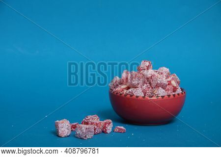Red Bowl Of Rahat Lakoum Isolated On Blue Background. Turkish Sweet Concept. Image Contains Copy Spa