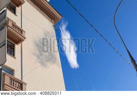 15.02.2021, Russia, Moscow. Cleaning The Roof Of The Snow After Heavy Snowfall. Blue Sky In The Back