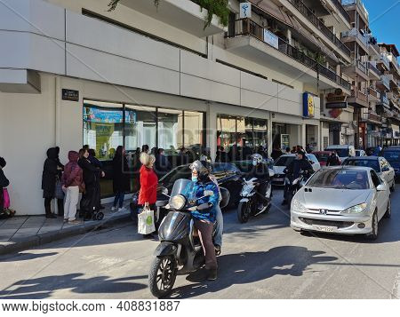 Thessaloniki, Greece February - 18 2021: Crowd With Covid-19 Masks Queuing Outside Super Market. Lar