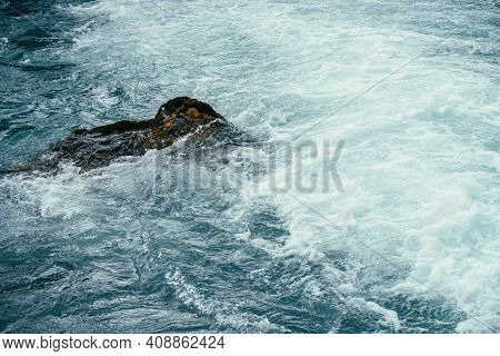 Mossy Stone In Azure Water Of Mountain River Close-up. Blue Nature Background With Boulder With Moss