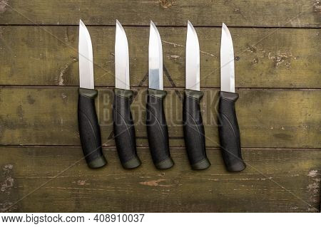 Several Identical Knives Lying In A Row. There Are Many Knives On The Table.