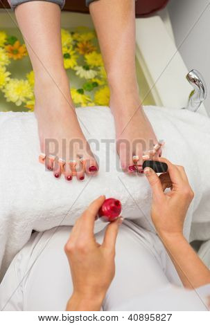 ウェルネス センターで爪のつま先に爪ニスを適用する女性のクローズ アップ
