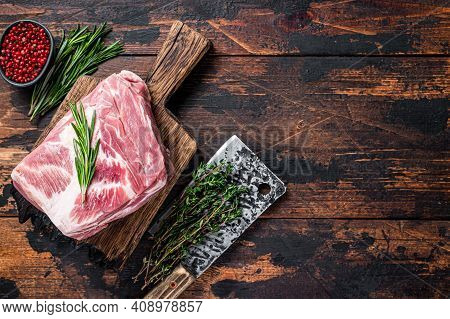 Pork Shoulder Raw Meat For Fresh Steaks On Wooden Cutting Board With Butcher Cleaver. Dark Wooden Ba