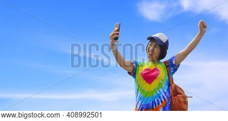 Asian Female Traveler In Colorful Casual Style Using Smartphone Taking Selfie With Smiling Cheerfull
