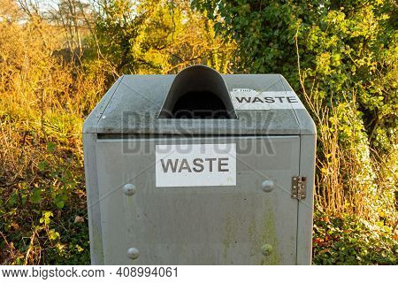Waste Sign On A Silver Steel Trash Can Or Bin In The Countryside Park