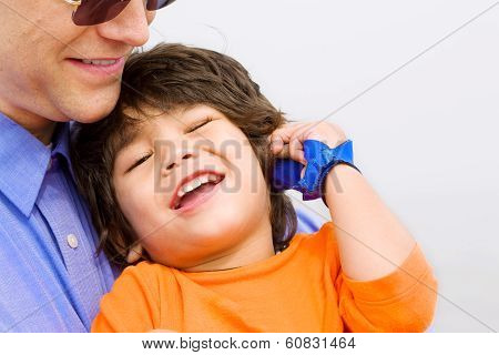 Father And Son Laughing Together On Beach