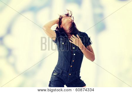 Sexy, beautiful, young woman dancing (hair flying) in jeans siut