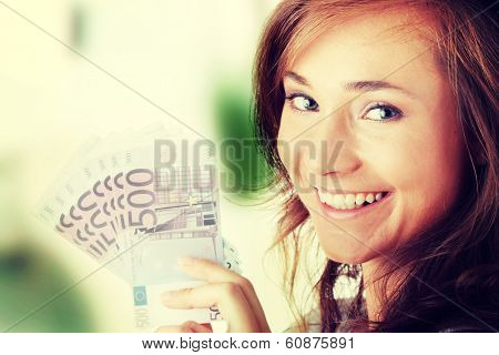 Happy young woman holding money