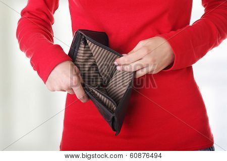 Young woman shows her empty wallet. Bankruptcy