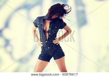Sexy, beautiful, young woman dancing (hair flying) in jeans siut