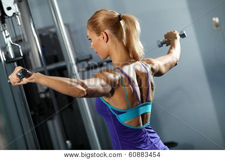 Image of fitness girl in gym exercising with dumbbells