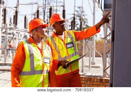 successful electrical engineers taking machine readings in substation