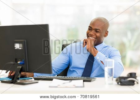 happy young african businessman working on computer