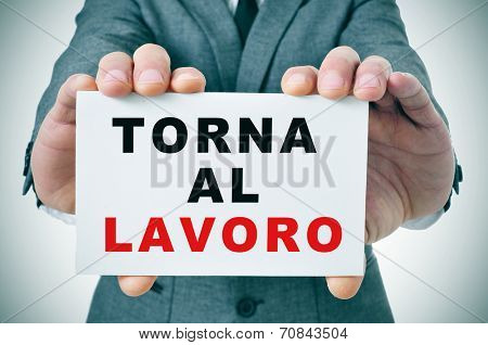 businessman holding a signboard with the text torna al lavoro, back to work in italian, written in it