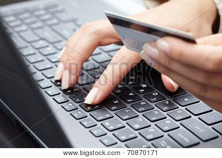 woman holding credit card on laptop for online shopping concep