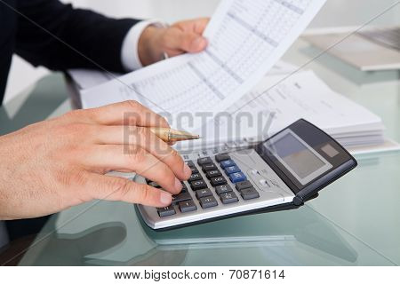 Businessman Holding Calculating Expense In Office