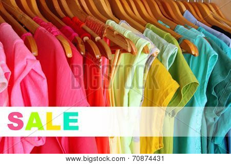 Concept of discount. Colorful clothes on hangers in wardrobe