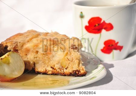Prato de torta de maçã com maçãs frescas com mel e xícara de chá