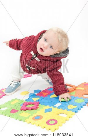 little child baby playing with puzzles warm cloth isolated on white studio shot