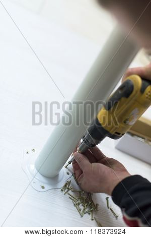 repairman working with drilling machine and assambling  furniture