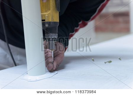 repairman working with drilling machine and assambling  furniture