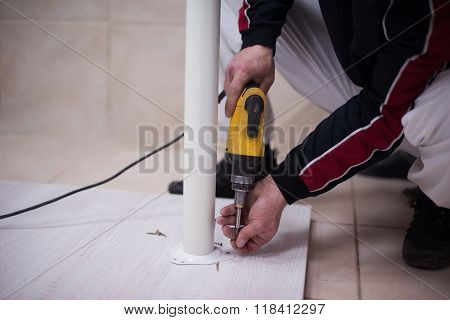 repairman working with drilling machine and assambling  furniture