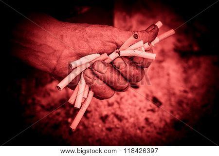 Hand man clenched. Fist of a man pushing a few cigarettes.