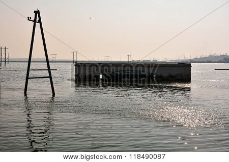 Pylons and building flooded by lake near Lokbatan, Azerbaijan