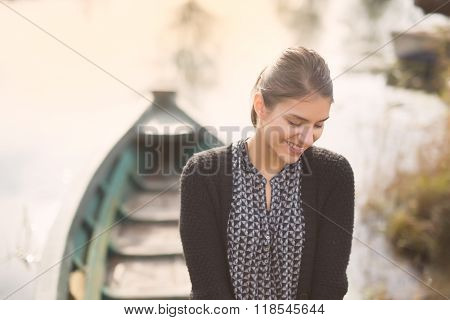 Young beautiful charming woman at the old fishing boat smiling.Honest reaction on male complimenting
